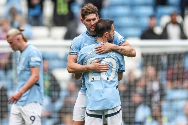 Manchester City 'den John Stones 14 Eylül 2024' te Etihad Stadyumu 'nda Manchester City ile Brentford arasındaki Premier League karşılaşmasında Manchester City' den Bernardo Silva 'yı kucaklıyor.