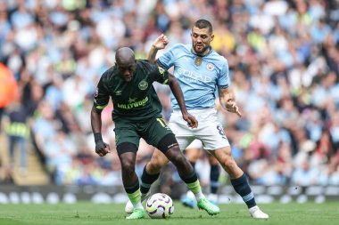 Yoane Wissa of Brentford  is tracked by Mateo Kovai of Manchester City during the Premier League match Manchester City vs Brentford at Etihad Stadium, Manchester, United Kingdom, 14th September 2024 clipart