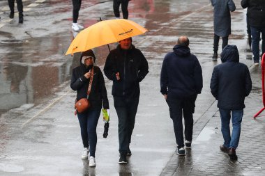 Taraftarlar, 15 Eylül 2024 'te Old Trafford, Manchester, İngiltere' de oynanan IT20 Serisi 'nin önünde yağmur yağmaya devam ederken şemsiyelerinin altına saklanıyorlar.