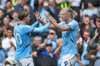 Manchester City 'den Erling Haaland, Manchester City ile Manchester City' nin 14 Eylül 2024 'te Etihad Stadyumu' nda oynanan Premier League karşılaşmasında Manchester City 'li Jack Grealish ile 2-1 kazanma hedefini kutluyor.