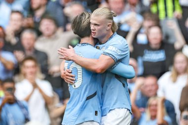 Manchester City 'den Erling Haaland, Manchester City ile Manchester City' nin 14 Eylül 2024 'te Etihad Stadyumu' nda oynanan Premier League karşılaşmasında Manchester City 'li Jack Grealish ile 2-1 kazanma hedefini kutluyor.