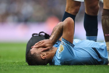 Manchester City 'den Rodri, 22 Eylül 2024' te Etihad Stadyumu 'nda oynanan Premier League maçında yaralandığı için tedavi gördüğü sırada yüzünü acı içinde tutuyor.