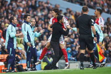 Arsenal 'den Riccardo Calafiori, Arsenal' in Mikel Arteta teknik direktörü ile 22 Eylül 2024 tarihinde Etihad Stadyumu 'nda oynanan Premier League maçında Manchester City-Arsenal maçında 1-1' lik galibiyetini kutluyor.