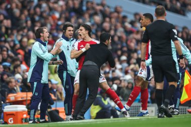 Arsenal 'den Riccardo Calafiori, Arsenal' in Mikel Arteta teknik direktörü ile 22 Eylül 2024 tarihinde Etihad Stadyumu 'nda oynanan Premier League maçında Manchester City-Arsenal maçında 1-1' lik galibiyetini kutluyor.