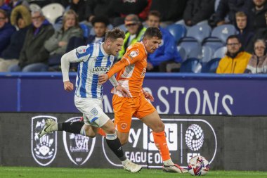 Huddersfield Town 'dan Ben Wiles ve Blackpool' dan Albie Morgan 24 Eylül 2024 'te John Smith Stadyumu' nda oynanan Sky Bet 1 karşılaşmasında top için mücadele ettiler.