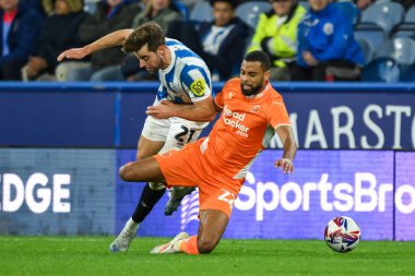 CJ Hamilton of Blackpool is fouled by Antony Evans of Huddersfield Town l  during the Sky Bet League 1 match Huddersfield Town vs Blackpool at John Smith's Stadium, Huddersfield, United Kingdom, 24th September 2024 clipart