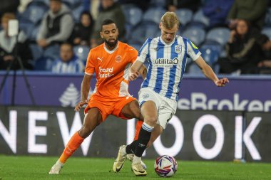 Blackpool 'dan CJ Hamilton ve Huddersfield Town' dan Lasse Srensen 24 Eylül 2024 'te John Smith Stadyumu' ndaki Huddersfield Town-Blackpool maçında top için mücadele ettiler.