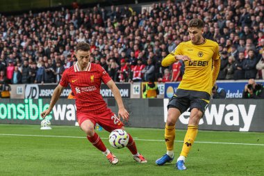 Santiago Bueno of Wolverhampton Wanderers passes the ball under pressure from Diogo Jota of Liverpool during the Premier League match Wolverhampton Wanderers vs Liverpool at Molineux, Wolverhampton, United Kingdom, 28th September 2024 clipart