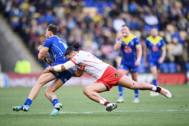 Warrington Wolves takımından Matty Ashton, St. Helens 'li Sione Mata' utia 'nın baskısı altında, Halliwell Jones Stadyumu, Warrington, İngiltere, 28 Sep 2024' te oynanan Betfred Süper Lig eleme maçında topla koşuyor.