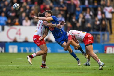 St. Helens takımından Jonny Lomax ve St. Helens takımından Sione Matautia 'nın Betfred Süper Lig eleme maçında Halliwell Jones Stadyumu' nda oynadıkları 2 Warrington Wolves 'a karşı St. Helens maçında topu indiriyor.