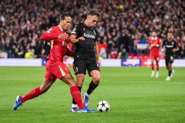 Liverpool 'dan Virgil van Dijk, UEFA Şampiyonlar Ligi - Lig Stage maçı sırasında Anfield, Liverpool, Liverpool, Birleşik Krallık' ta 2 Ekim 2024 tarihinde Bologna 'lı Thijs Dallinga ile top mücadelesi verdi.