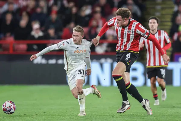 Swansea City 'den Ollie Cooper, Sheffield United' ın 2 Ekim 2024 'te Bramall Lane, Sheffield, İngiltere' de oynanan Sky Bet Şampiyonası karşılaşmasında Sheffield United ile Swansea City arasındaki maçta Harry Souttar arasında faul yaptı.