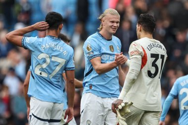 Manchester City 'den Erling Haaland, Manchester City ile 5 Ekim 2024' te Etihad Stadyumu 'nda oynanan Premier League maçında 3-1 kazandıktan sonra Manchester City' den Ederson ile tokalaşıyor.