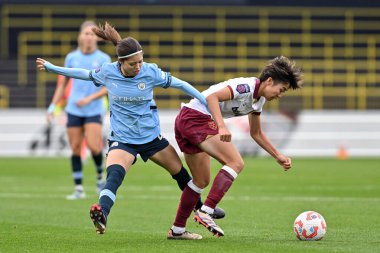 West Ham United Women 'dan Riko Ueki ve Manchester City Women' dan Yui Hasegawa Manchester 'daki Joie Stadyumu' nda oynanan Manchester City Kadınlar Süper Ligi karşılaşmasında top için mücadele ediyorlar.,