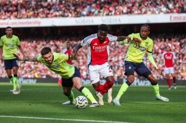 Arsenal 'den Bukayo Saka, Southampton' dan Ryan Manning ve Kyle Walker-Peters ile 5 Ekim 2024 'te Emirates Stadyumu' nda oynanan Premier League maçı sırasında top için mücadele etti.