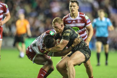 Wigan Warriors 'dan Junior Nsemba ve Leopar Leopards' dan Jack Hughes, 5 Ekim 2024 'te İngiltere' nin Wigan şehrindeki Brick Community Stadyumu 'nda oynanan Betfred Süper Lig Yarı Finalleri' nde Wigan Warriors - Leigh Leopards maçında top için mücadele ediyorlar.