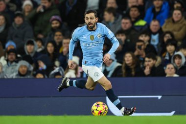 Manchester City 'den Bernardo Silva, Manchester City' nin 23 Kasım 2024 'te Etihad Stadyumu' nda Tottenham Hotspur 'a karşı oynadığı Premier League maçında topa vuruyor.