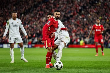 Real Madrid 'den Jude Bellingham, UEFA Şampiyonlar Ligi, Lig Faz MD5 Liverpool - Real Madrid Anfield, Liverpool, Birleşik Krallık' ta 27 Kasım 2024 tarihinde Liverpool 'lu Mohamed Salah ile top mücadelesi veriyor.