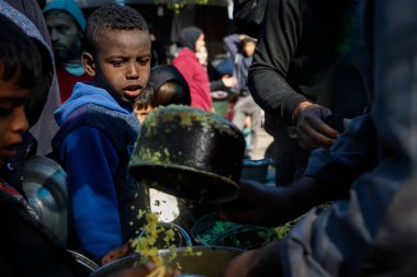 Filistinliler, Amerikan Dünya Mutfağı 'nı üst üste ikinci kez kapatma kararı sonrasında geçici bir sürgün kampında bedava yemek yemeye çalıştılar ve bu da güneydeki yerlerinden edilen Filistinlilerin durumunu daha da kötüleştirdi.