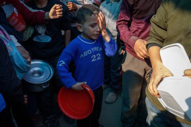 Filistinliler, Amerikan Dünya Mutfağı 'nı üst üste ikinci kez kapatma kararı sonrasında geçici bir sürgün kampında bedava yemek yemeye çalıştılar ve bu da güneydeki yerlerinden edilen Filistinlilerin durumunu daha da kötüleştirdi.