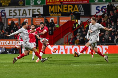Wrexham 'dan Ollie Palmer gol atıyor ama 3 Aralık 2024' te Wrexham-Barnsley maçında Barnsley 'li Marc Roberts tarafından engelleniyor.