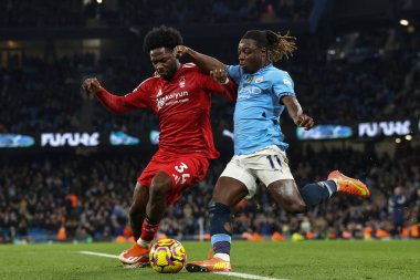 Nottingham Ormanı 'ndan Ola Aina ve Manchester City' den Jrmy Doku Premier Lig maçı sırasında Etihad Stadyumu 'nda Manchester City Nottingham Ormanı' na karşı 4 Aralık 2024 'te top mücadelesi veriyor.