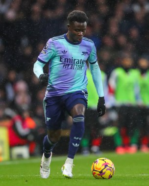 Arsenal 'den Bukayo Saka, Premier Lig maçında topu Craven Cottage, Londra, İngiltere' de 8 Aralık 2024 'te Fulham-Arsenal maçında attı.