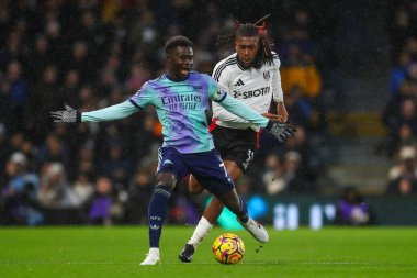 Arsenal 'den Bukayo Saka, 8 Aralık 2024' te Craven Cottage, Londra, İngiltere 'de oynanan Premier League maçında Fulham-Arsenal maçında Fulham' ın Alex Iwobi 'den gelen baskıya tepki gösterdi.