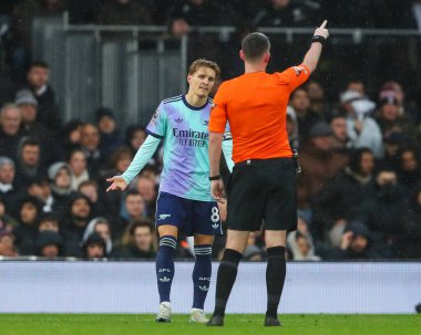 Hakem Chris Kavanagh, 8 Aralık 2024 'te Craven Cottage, Londra' da oynanan Premier League maçında Arsenal 'den Martin degaard ile konuştu.
