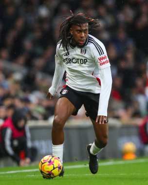 Fulham 'dan Alex Iwobi Premier Lig maçında Craven Cottage, Londra, İngiltere' de 8 Aralık 2024 'te Fulham-Arsenal maçında topa vuruyor.