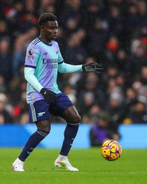 Arsenal 'den Bukayo Saka, Premier Lig maçında topu Craven Cottage, Londra, İngiltere' de 8 Aralık 2024 'te Fulham-Arsenal maçında attı.