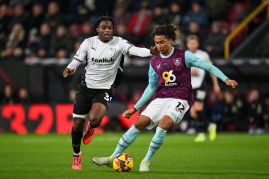 Burnley 'den Bashir Humphreys, Derby County' den Ebou Adams 'ın baskısıyla 10 Aralık 2024' te Burnley - Derby County Turf Moor, Burnley, Birleşik Krallık 'ta oynanan maçta topu geçiyor.