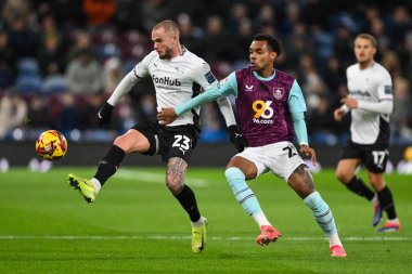 Derby County 'den Joe Ward, Burnley' li Lucas Pires 'ın 10 Aralık 2024' te Turf Moor, Burnley, İngiltere 'de Burnley' e karşı oynadığı Gökyüzü İddia Şampiyonası maçında yaptığı baskıya rağmen topu kontrol ediyor.