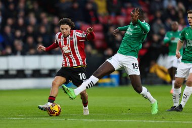 Sheffield United takımından Callum O 'Hare, Sheffield Lane, Sheffield, İngiltere' de 14 Aralık 2024 'te oynanan Sky Bet Şampiyonası karşılaşmasında Plymouth Argyle takımından Mustafa Bundu' nun baskısı altında.
