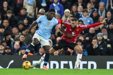 Manchester City 'den Jeremy Doku, Manchester City' nin Manchester United 'a karşı 15 Aralık 2024' te Etihad Stadyumu 'nda oynadığı Premier League maçında Manchester United' dan Matthijs de Ligt 'i durdurdu.