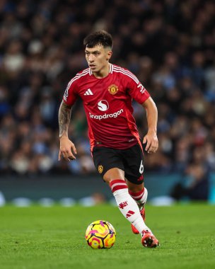 Manchester United takımından Lisandro Martnez, Manchester United ile 15 Aralık 2024 'te Etihad Stadyumu' nda oynanan Premier League maçında topa vuruyor.