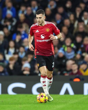 Manchester United takımından Diogo Dalot, Manchester United ile 15 Aralık 2024 'te Etihad Stadyumu' nda oynanan Premier League maçında topa vuruyor.