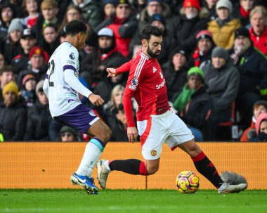 Manchester United takımından Bruno Fernandes 22 Aralık 2024 'te Old Trafford, Manchester, İngiltere' de oynanan Premier League maçında Bournemouth 'lu Tyler Adams' a karşı topa vuruyor.