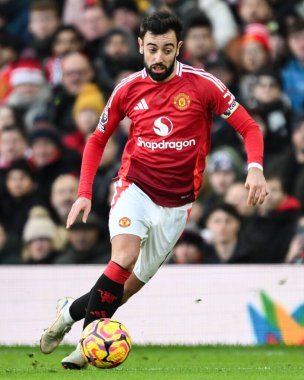 Manchester United takımından Bruno Fernandes 22 Aralık 2024 'te Old Trafford, Manchester, İngiltere' de oynanan Premier League maçında topa doğru ilerliyor.