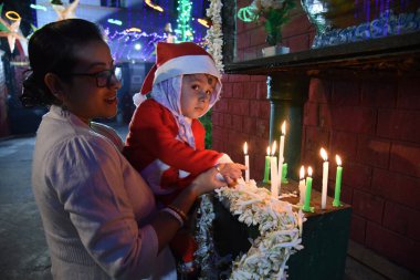 24 Aralık 2024 'te Kolkata, Hindistan' da İsa Mesih 'in doğumu münasebetiyle Aziz Teresa Kilisesi' nde dua eden küçük bir çocuk..