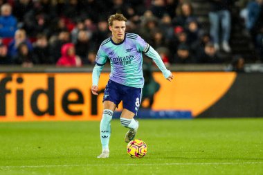 Arsenal 'den Martin Odegaard, 1 Ocak 2025' te Londra 'daki Gtech Community Stadyumu' nda Premier League maçında Brentford 'a karşı Arsenal maçında topla koşuyor.