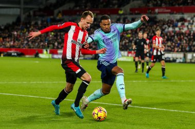 Brentford 'dan Mikkel Damsgaard, 1 Ocak 2024' te İngiltere 'deki Gtech Community Stadyumu' nda oynanan Premier League maçı Brentford-Arsenal maçında Arsenal 'li Gabriel ile top için mücadele ediyor.