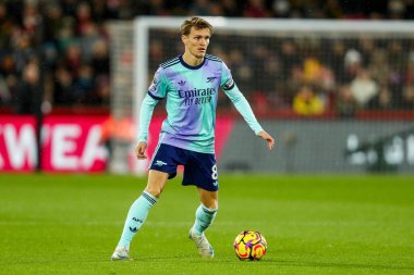 Arsenal 'den Martin Odegaard, 1 Ocak 2025' te Londra 'daki Gtech Community Stadyumu' nda Premier League maçında Brentford 'a karşı Arsenal maçında topla koşuyor.