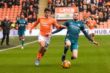 Blackpool 'dan Rob Apter ve Shrewsbury Town' dan Carl Winchester, 1 Ocak 2025 'te Bloomfield Road, Blackpool' da oynanan Blackpool-Shrewsbury maçında top için mücadele ettiler.
