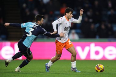 Blackpool 'dan Rob Apter, Wycombe Wanderers' ın 4 Ocak 2025 'te Adams Park, High Wycombe' da Wycombe Wanderers-Blackpool maçında Wycombe Wanderers 'dan Daniel Harvie' yi alt etti.