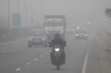 Soğuk bir kış sabahı Howrah, Batı Bengal 'de yoğun siste Ulusal Otoyol NH12 boyunca seyahat edenler 