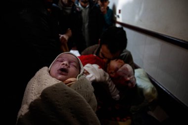 Yaralı bir baba, İsrail 'in bu sabah Deir al-Balah' taki evlerini hedef alan bombalı saldırıda ölen ve aynı saldırıda ölen annelerine ek olarak El Aksa Şehitleri Hastanesi 'ndeki oğluna ve kızına veda ediyor. 
