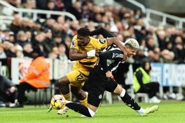 Wolverhampton Wanderers 'dan Emmanuel Agbadou ve Newcastle United' dan William Osula Premier League karşılaşmasında Newcastle United ile Wolverhampton Wanderers arasında 15 Ocak 2025 'te St. James' s Park, Newcastle, İngiltere 'de oynanan karşılaşmada top için savaştılar.