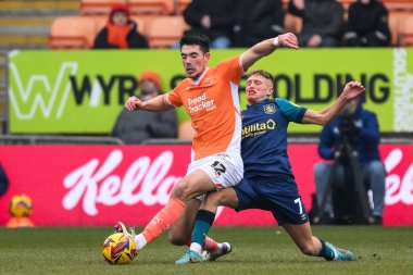 Blackpool 'dan Elkan Baggott ve Huddersfield Town' dan Callum Marshall 18 Ocak 2025 'te Bloomfield Road, Blackpool' da oynanan Blackpool-Huddersfield maçında top için mücadele ettiler.