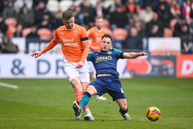 Blackpool 'dan Lee Evans topu Huddersfield Town' dan Joe Hodge 'un baskılarına rağmen 18 Ocak 2025' te Bloomfield Road, Blackpool 'da Blackpool Huddersfield Town' a karşı oynanan 1.